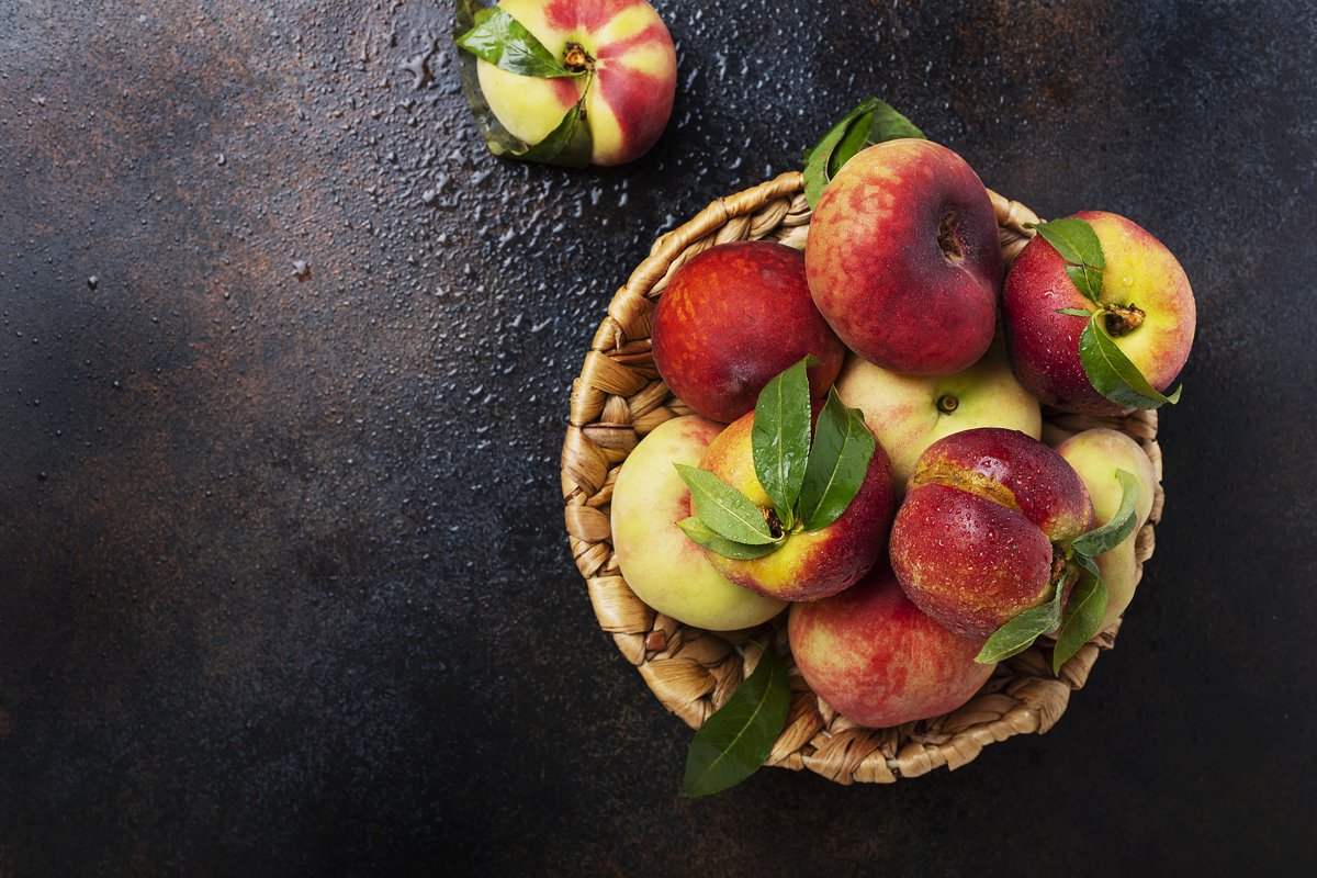 Top down view of sweet peaches with green leaves example image 1