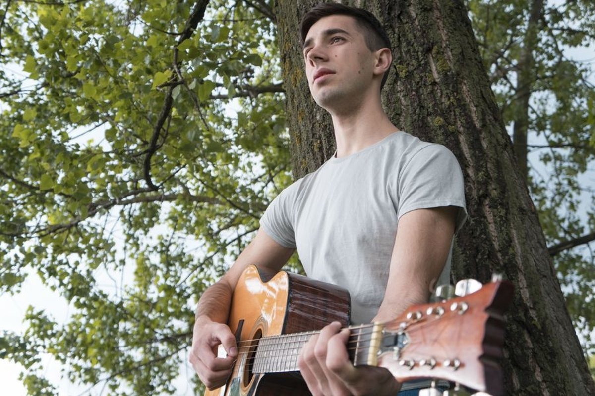 Young caucasian man with guitar in the park example image 1