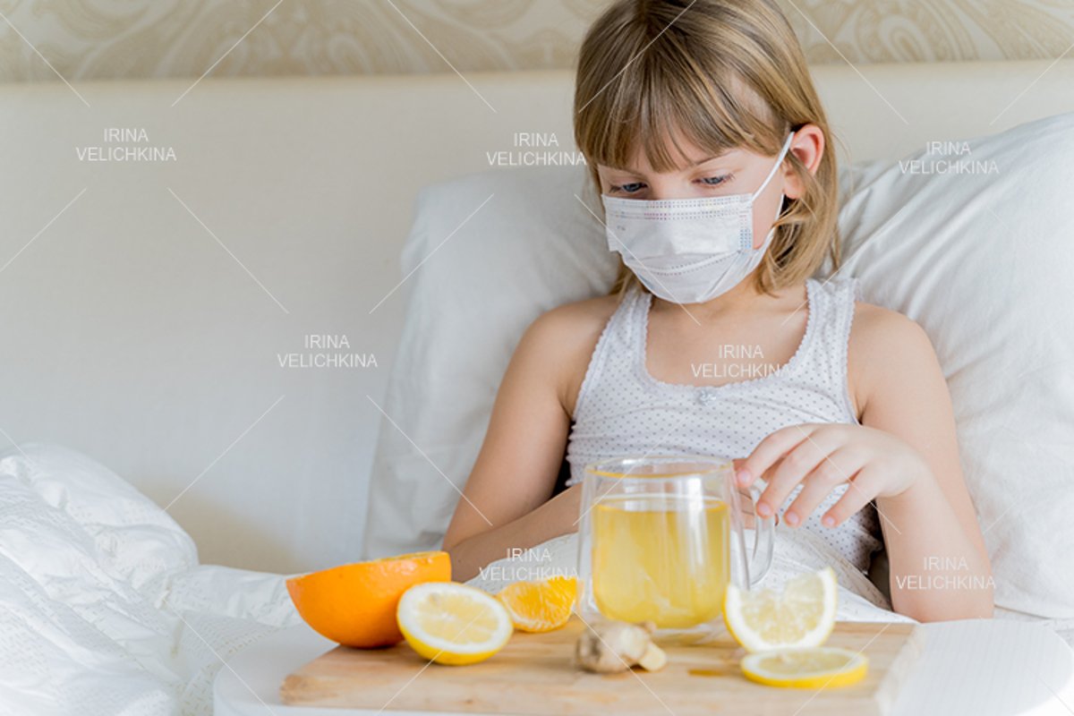 Sick girl in bed. Face mask.Cup of tea, orange,lemon,ginger example image 1