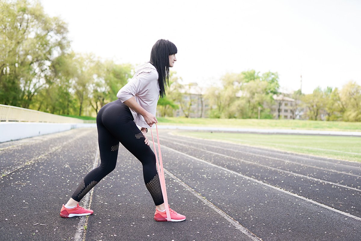 Young fitness girl doing stretching on the stadium example image 1