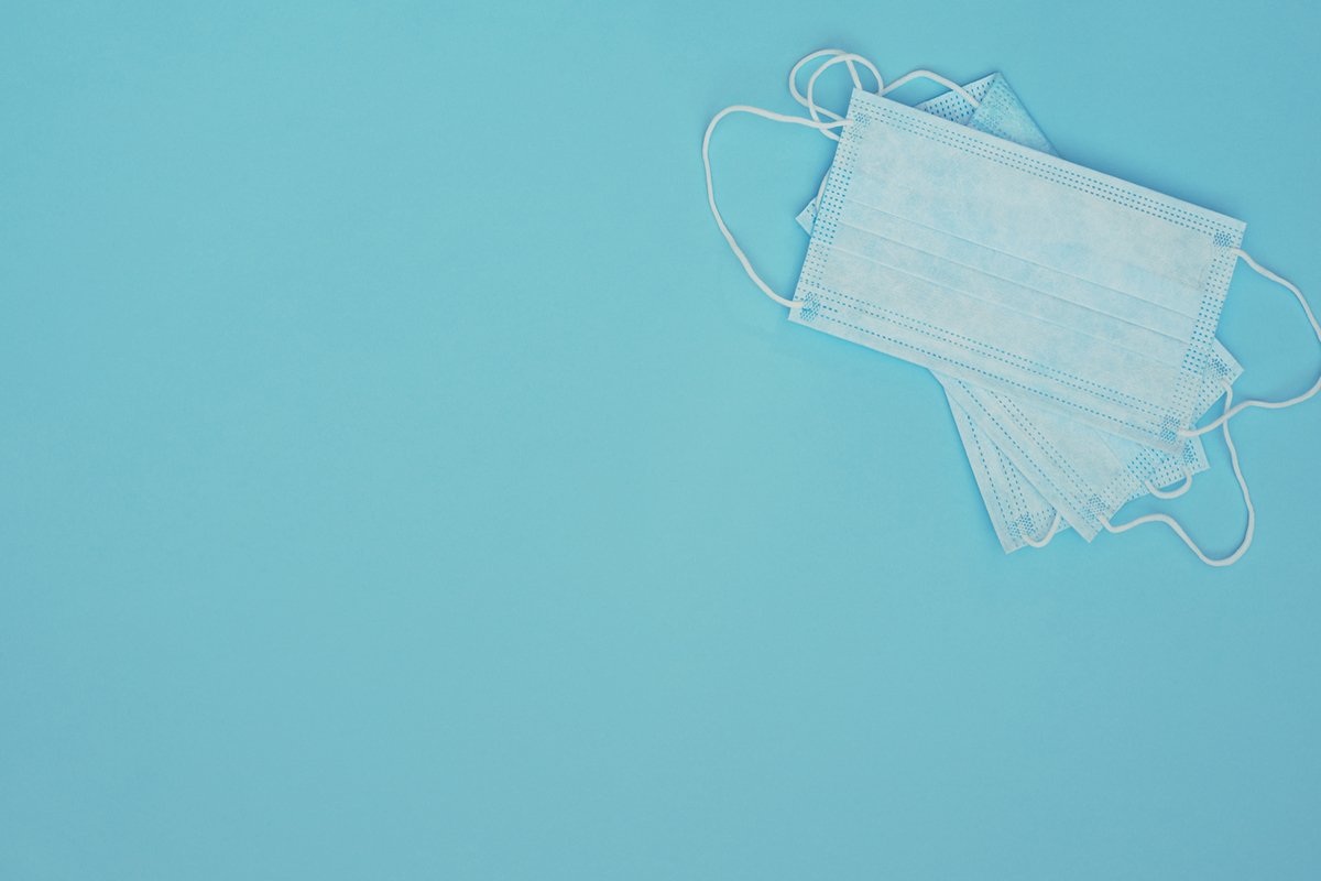 Light blue medical masks on blue background. example image 1
