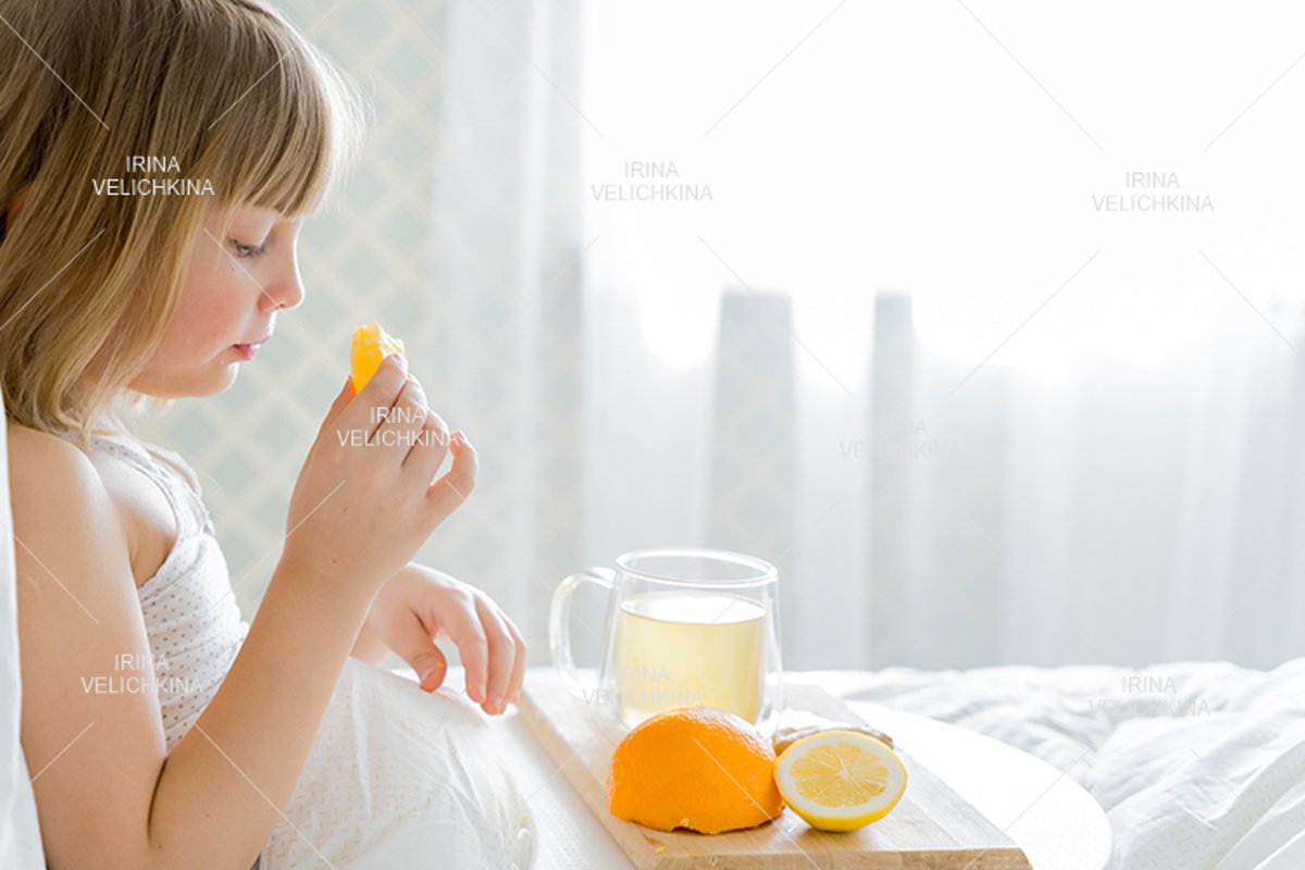 Sick girl in bed. Cup of flu drugs. Tea, orange,lemon,ginger example image 1