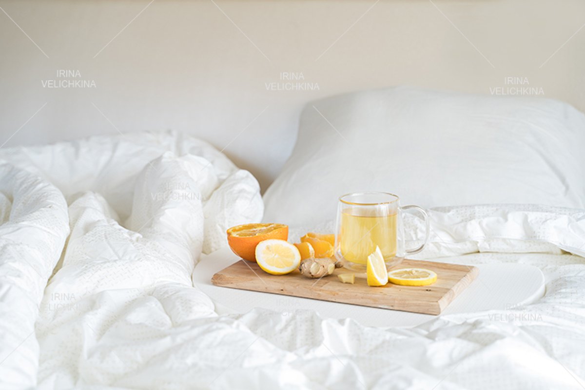 Cup of tea,orange,lemon,ginger in bed.Self treatment for flu example image 1