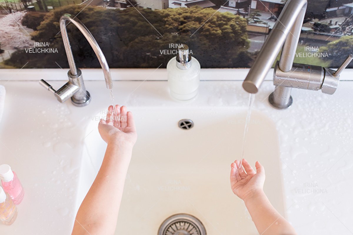 Girls wash their hands in the sink with soap in the foam example image 1