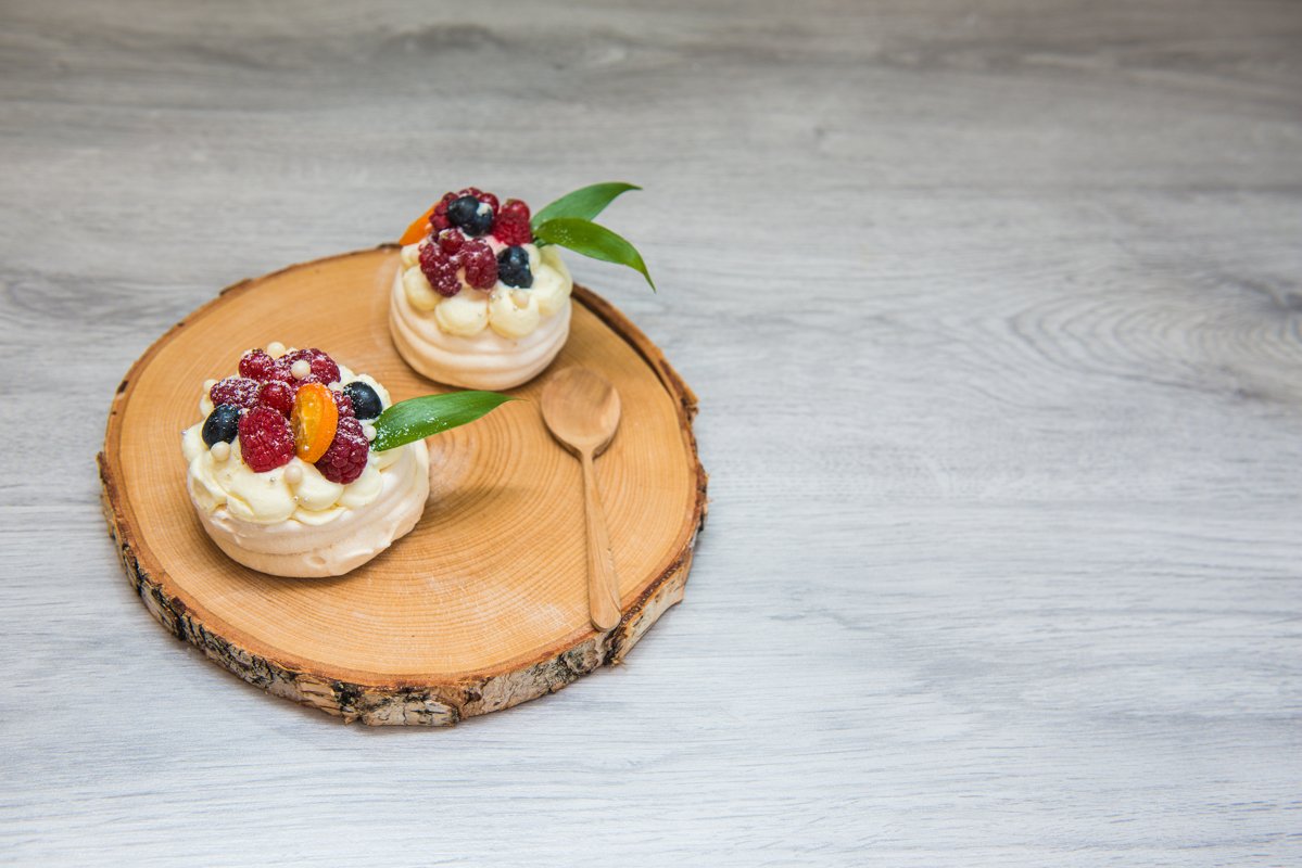 Pavlova meringue desert cake with cream and small fruits example image 1