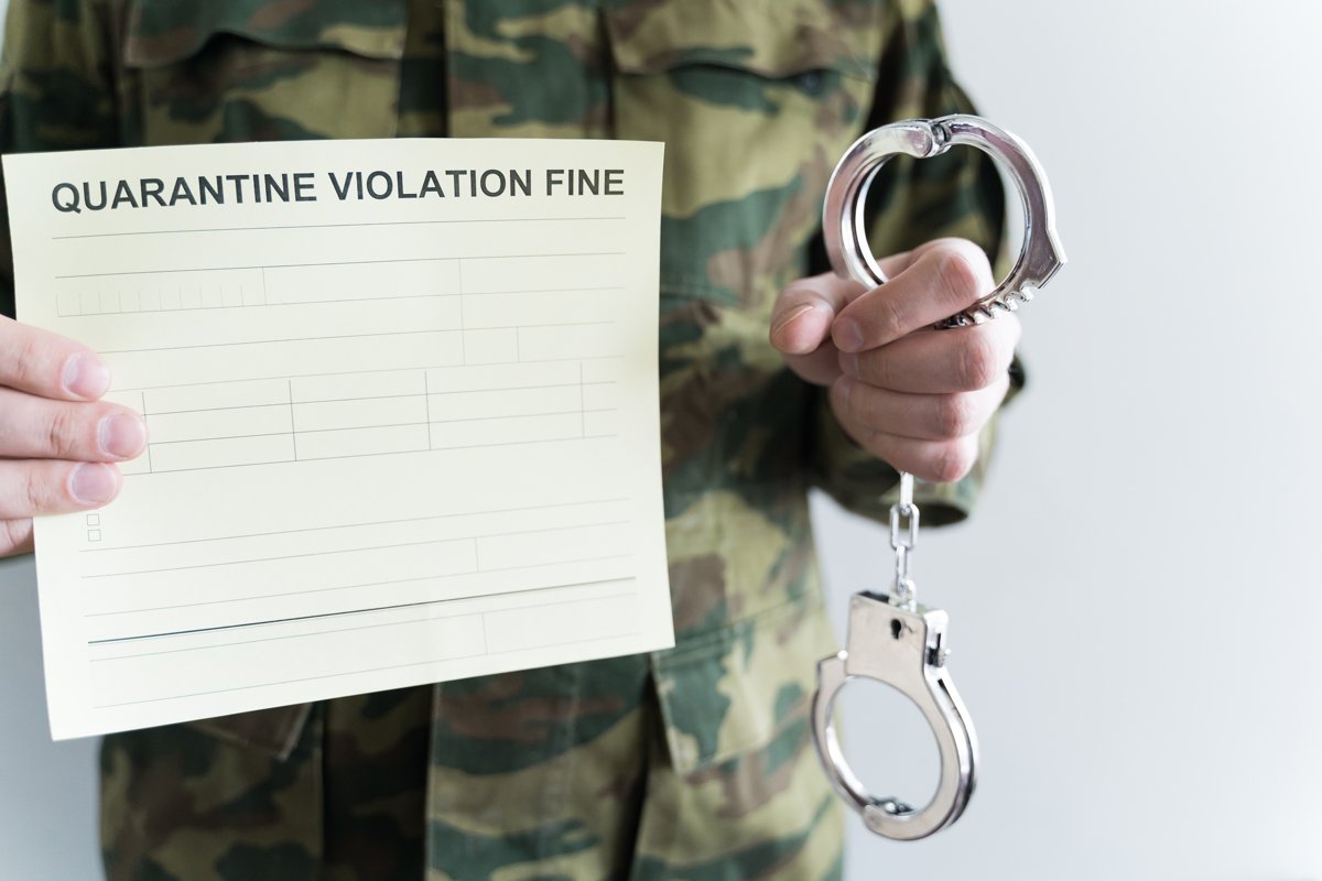 Police officer with handcuffs. Self-isolation violation fine example image 1