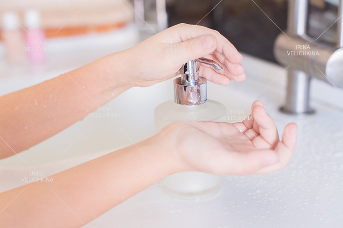 Girls wash their hands in the sink with soap in the foam example image 1