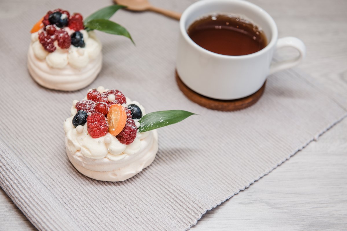 Pavlova meringue desert cake with cream and small fruits example image 1
