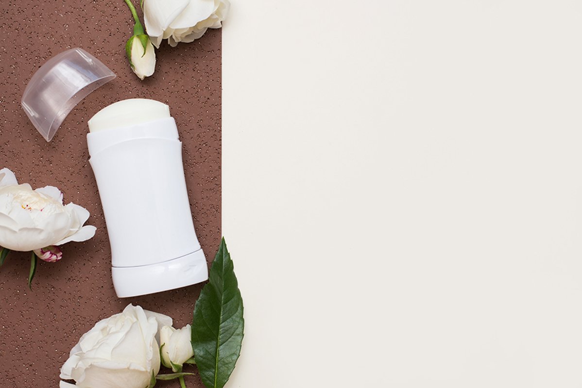 Flat lay composition with deodorant and flowers example image 1