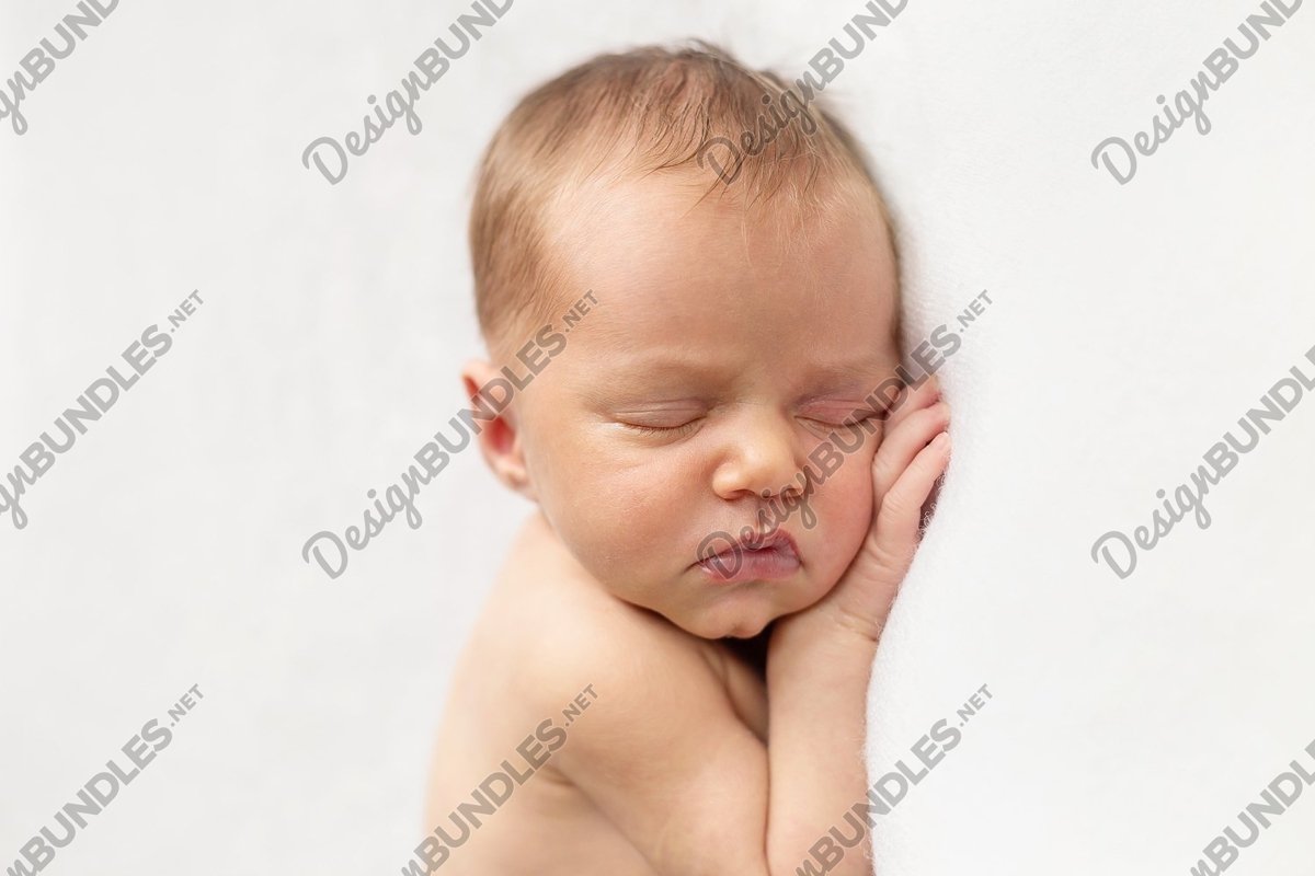Newborn baby girl is sleeping on the white background example image 1