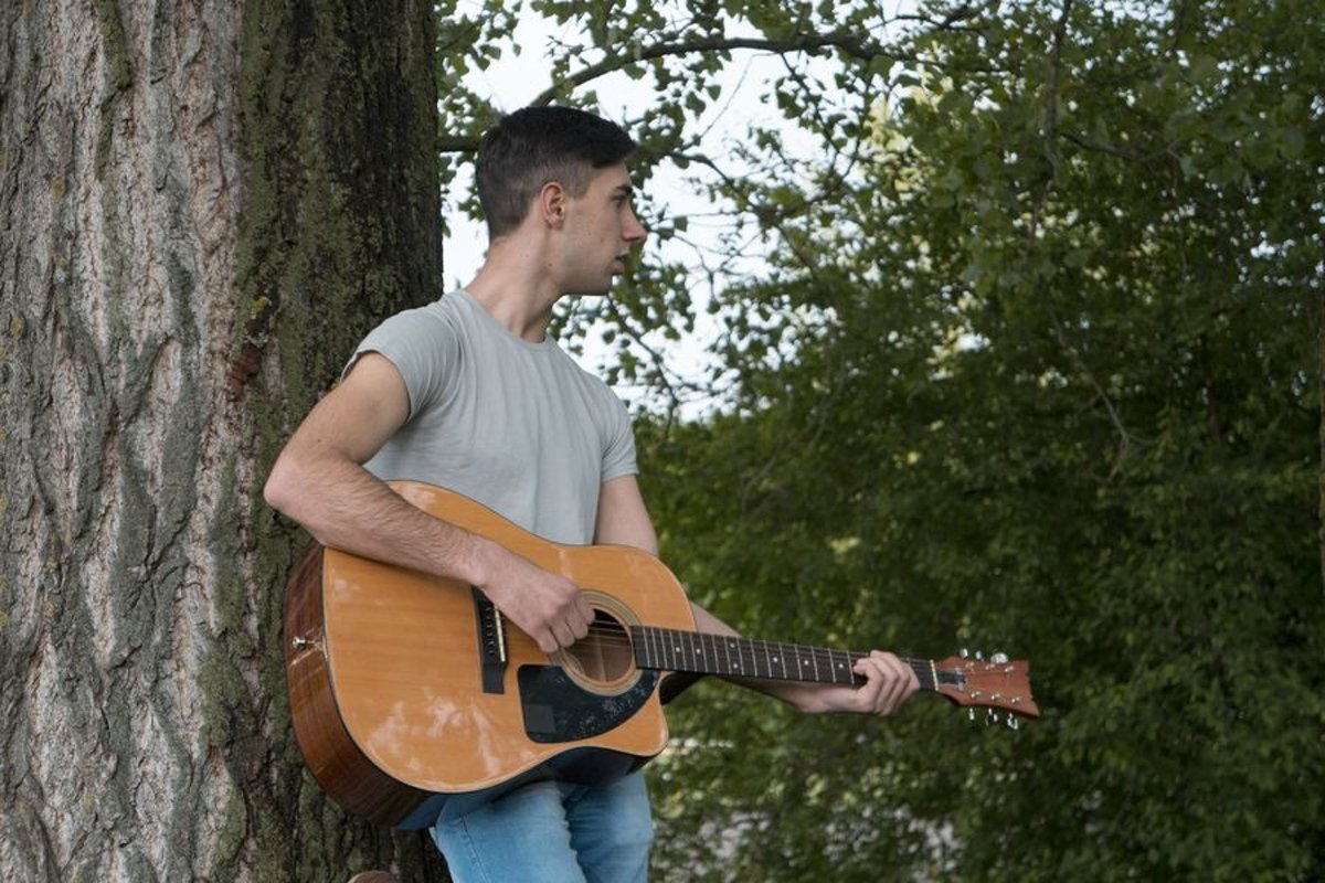 Young caucasian man with guitar in the park example image 1