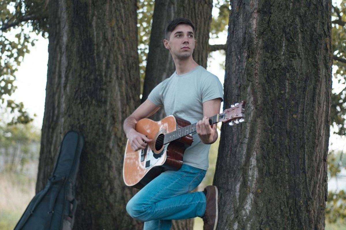 Man plays on acoustic guitar in park example image 1