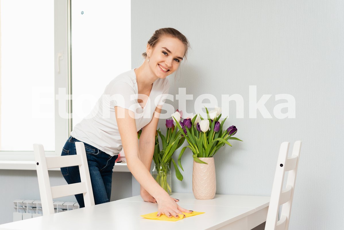 A cute blonde is smiling while cleaning her house example image 1