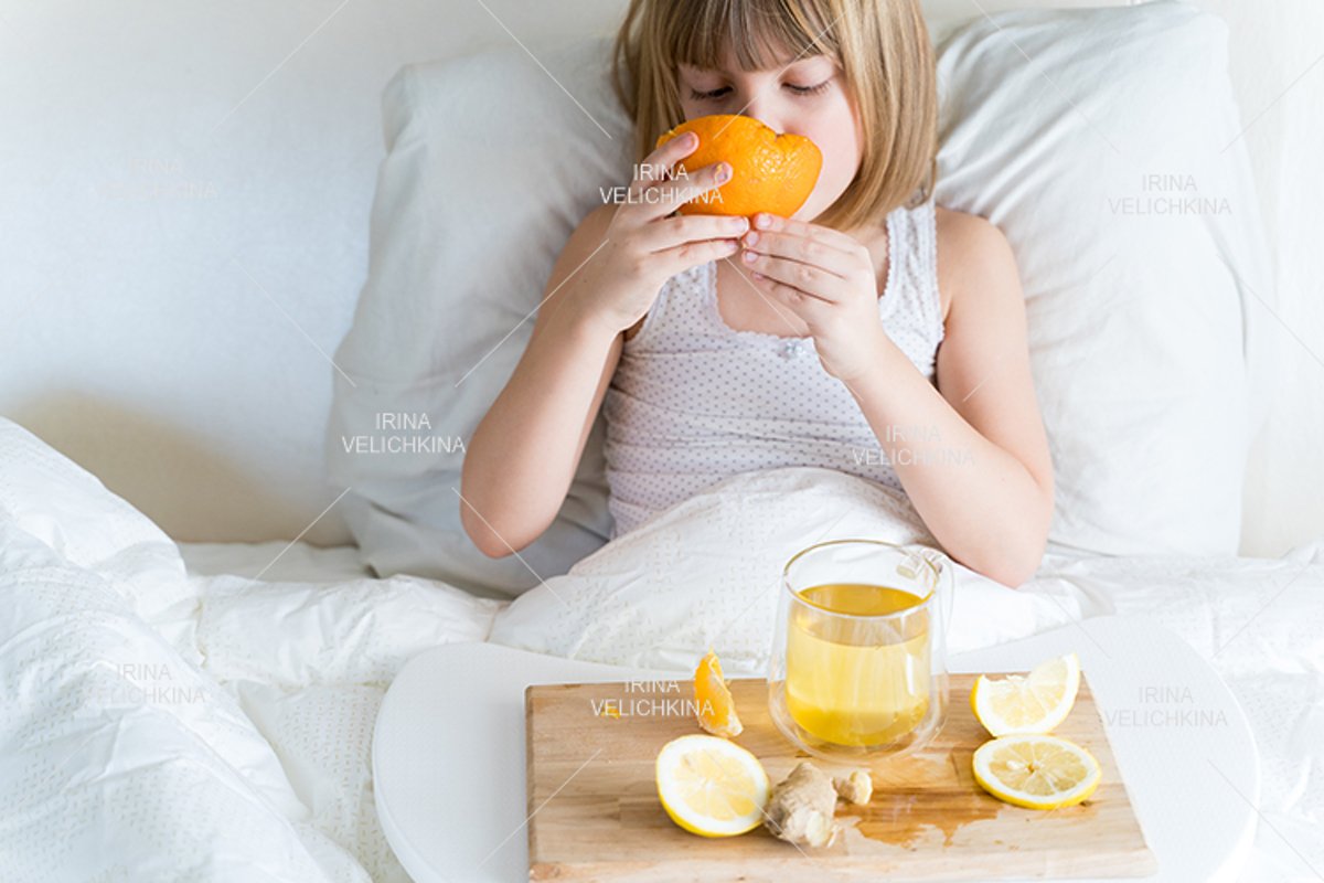 Sick girl in bed. Cup of flu drugs. Tea, orange,lemon,ginger example image 1