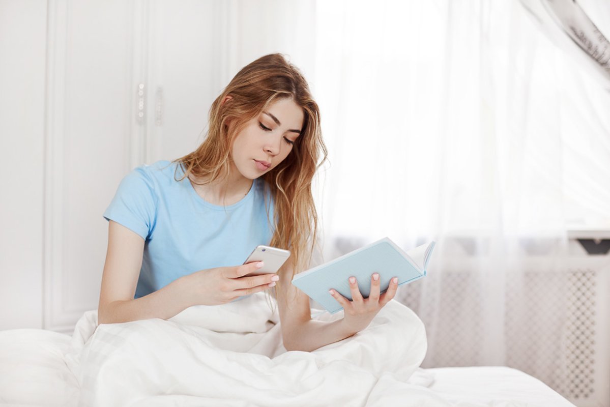 A pretty young girl is sitting on the bed in the bedroom example image 1