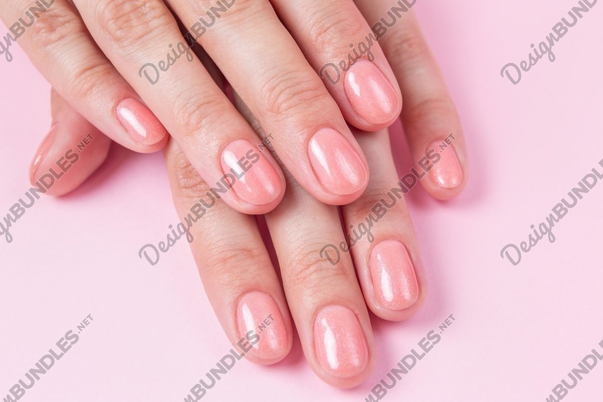 Nude nails covered with gel polish on a pink background example image 1