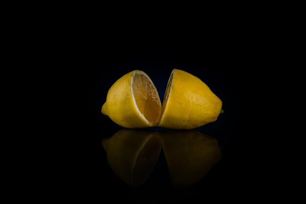 two halves of whole lemon on a black background example image 1