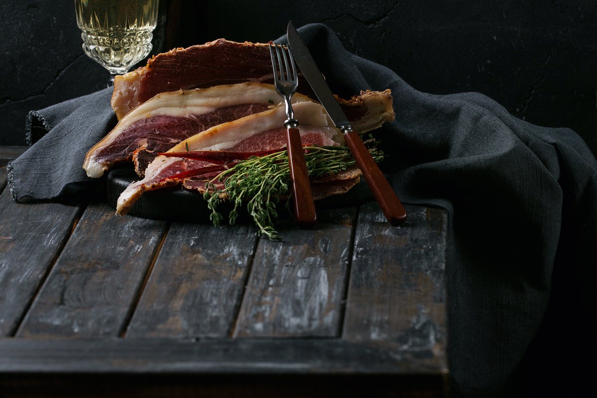 Prosciutto Ham served on a rustic wooden board example image 1