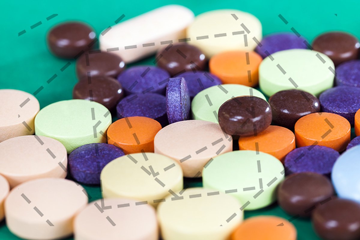 Multi-colored pills on a green background example image 1