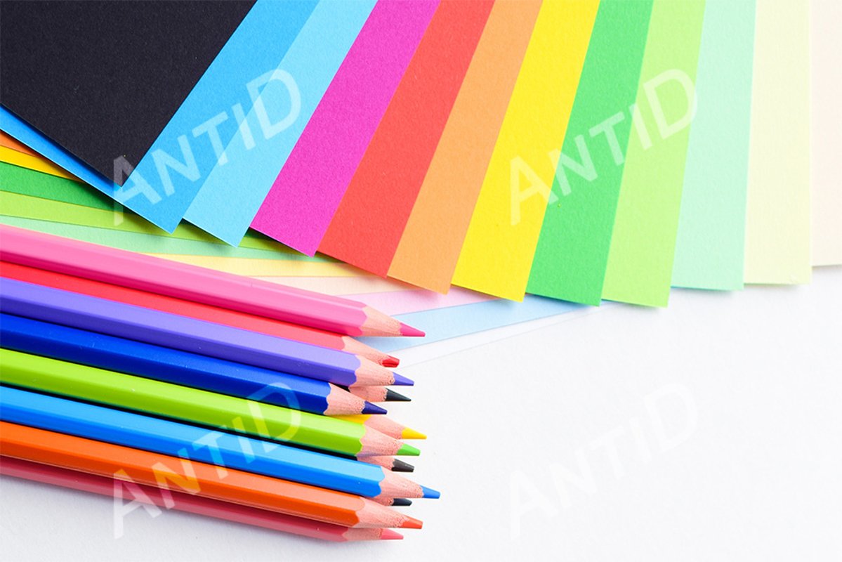 Colored pencils and colored paper on a white background example image 1