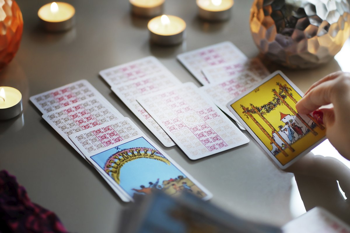 Tarot cards on table near burning candles, esoteric concept example image 1