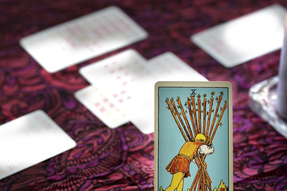 Tarot cards on table near burning candles, esoteric concept example image 1