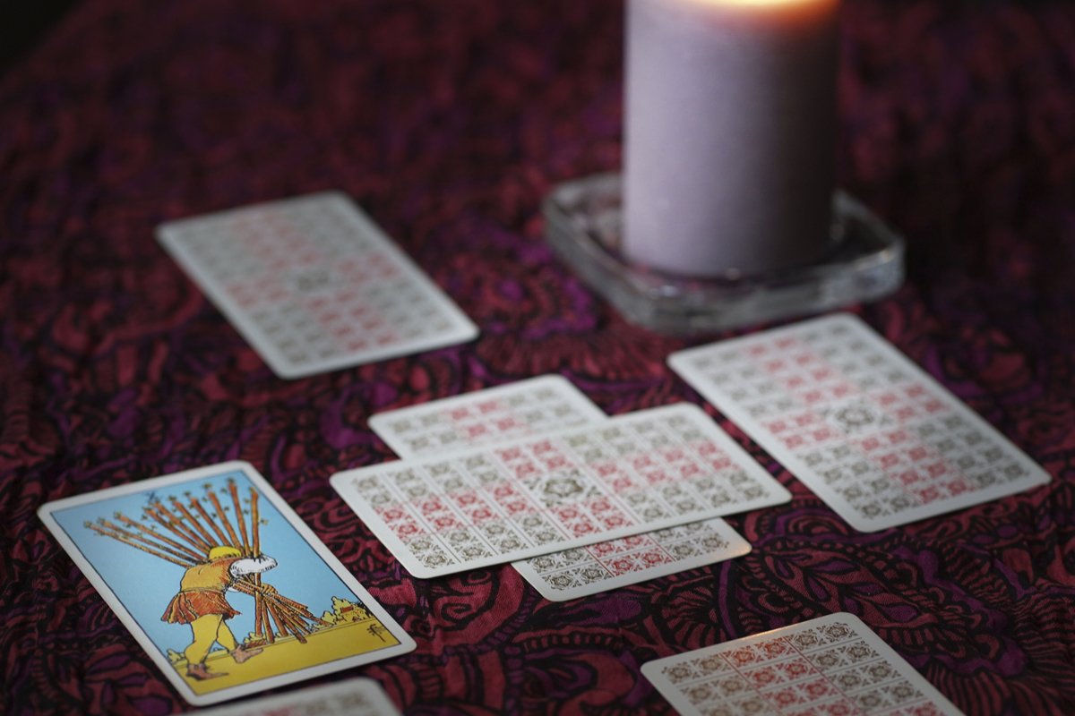 Tarot cards on table near burning candles, esoteric concept example image 1