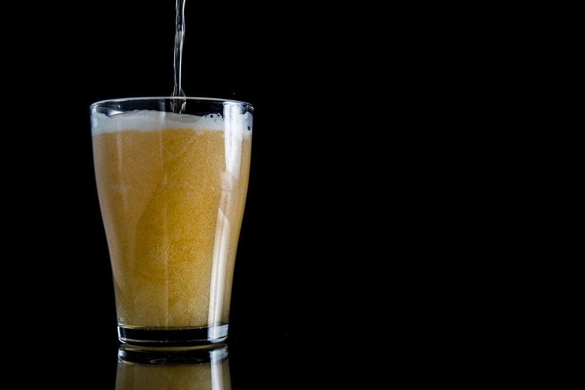 foam beer poured into a glass on a black background example image 1