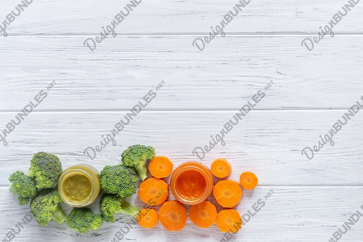 Glass jars with baby food on white wooden background example image 1