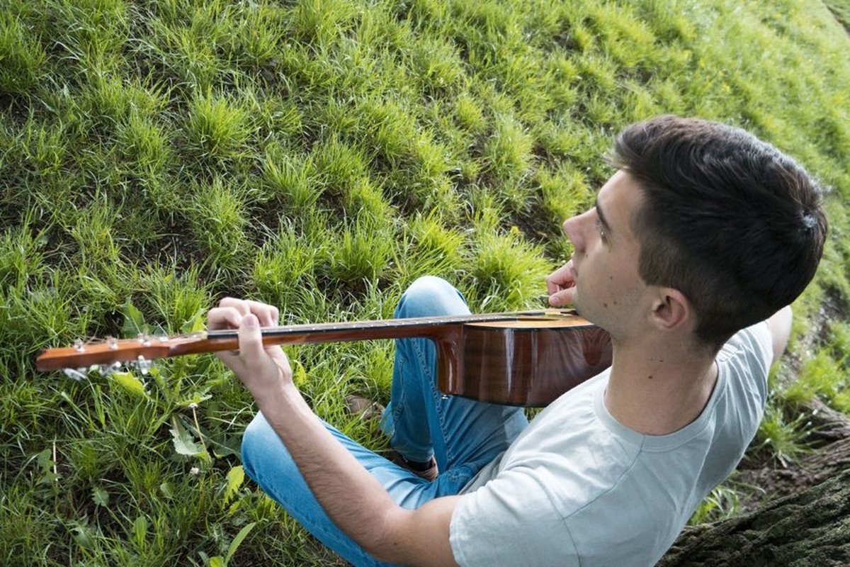 Young caucasian man with guitar in the park example image 1