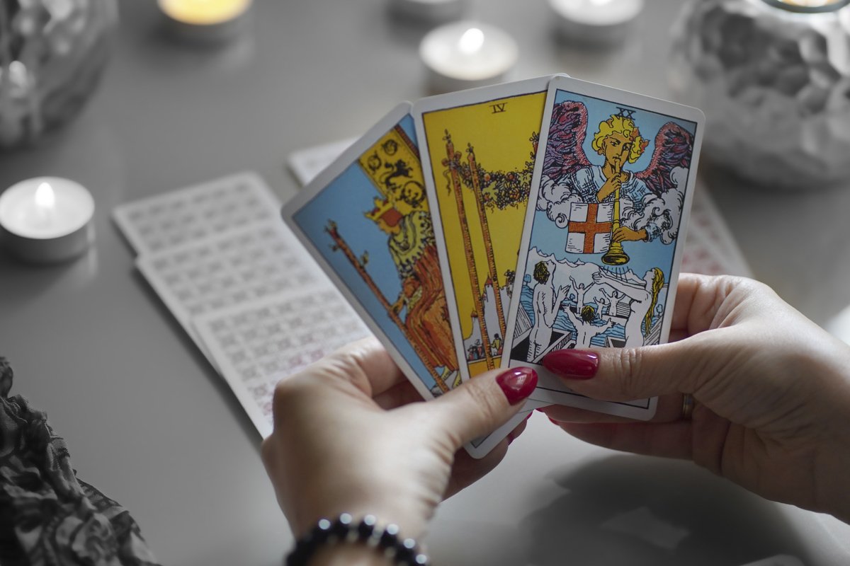 Tarot cards on table near burning candles, esoteric concept example image 1