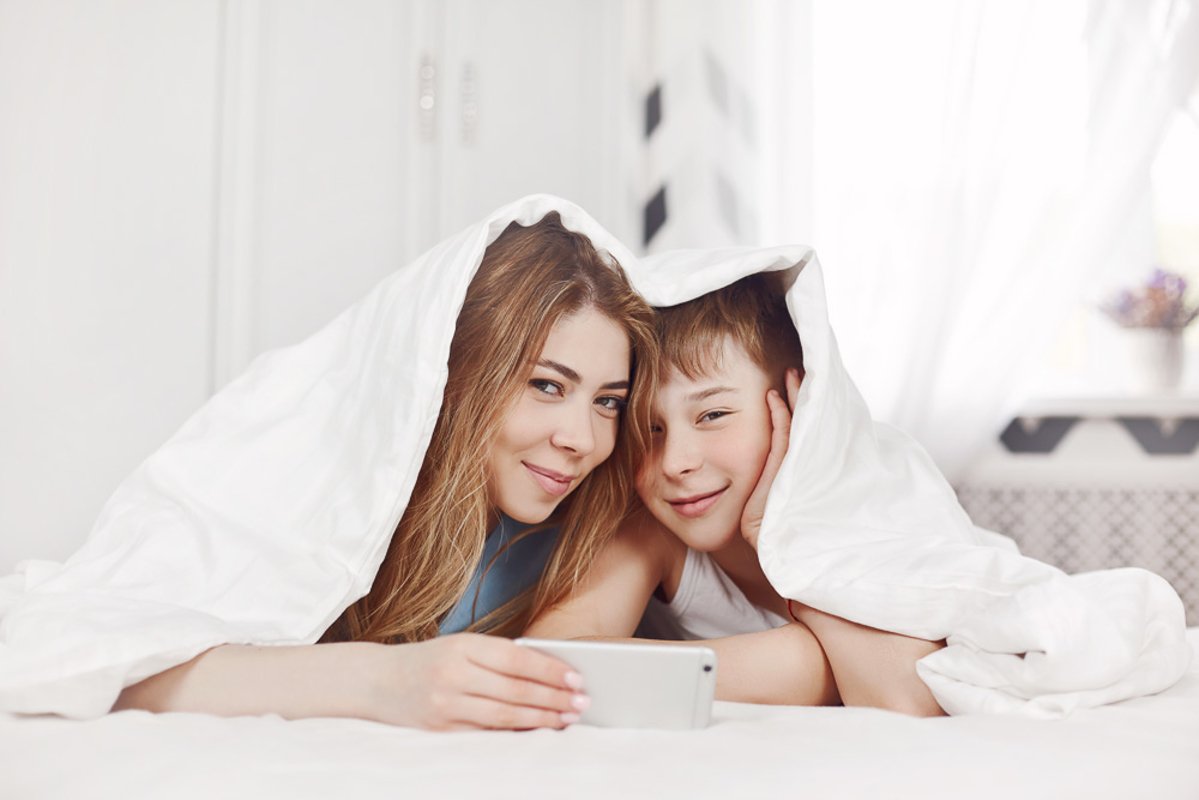 The girl and her younger brother look at photos on the phone example image 1