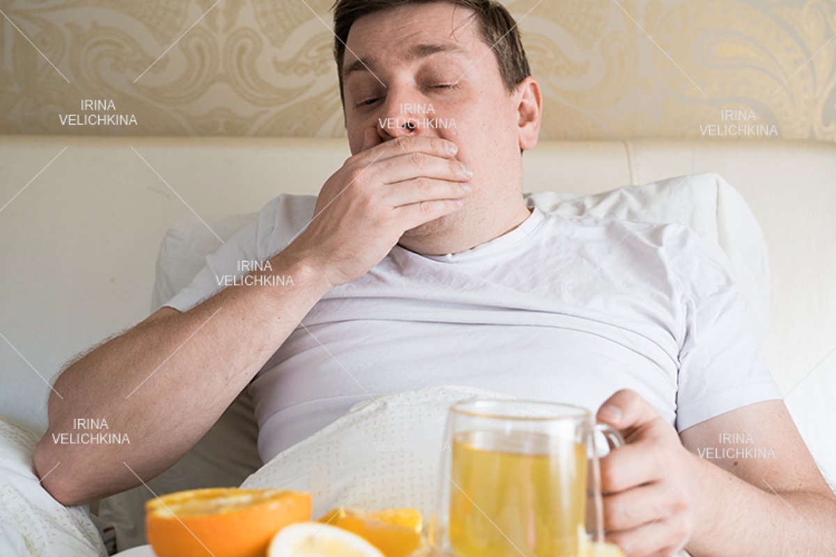 Sick man in bed. Cup of flu drugs. Tea, orange,lemon,ginger example image 1