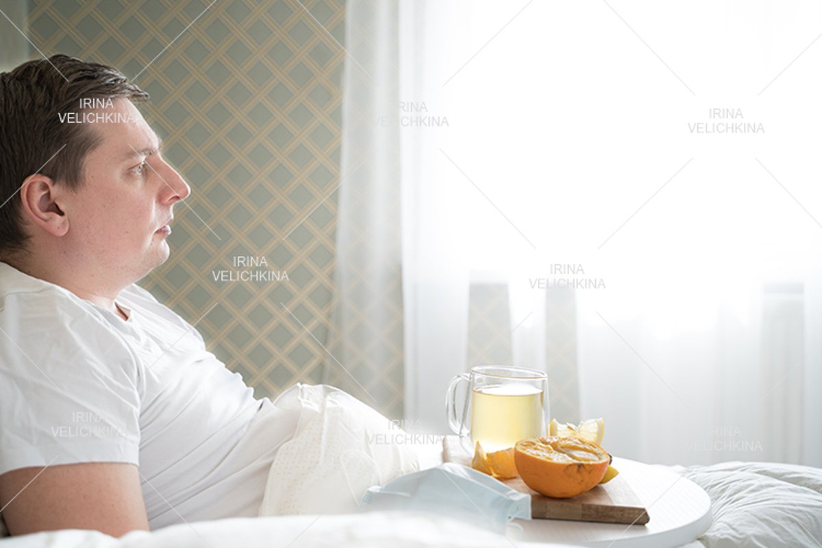 Sick man in bed. Cup of flu drugs. Tea, orange,lemon,ginger example image 1