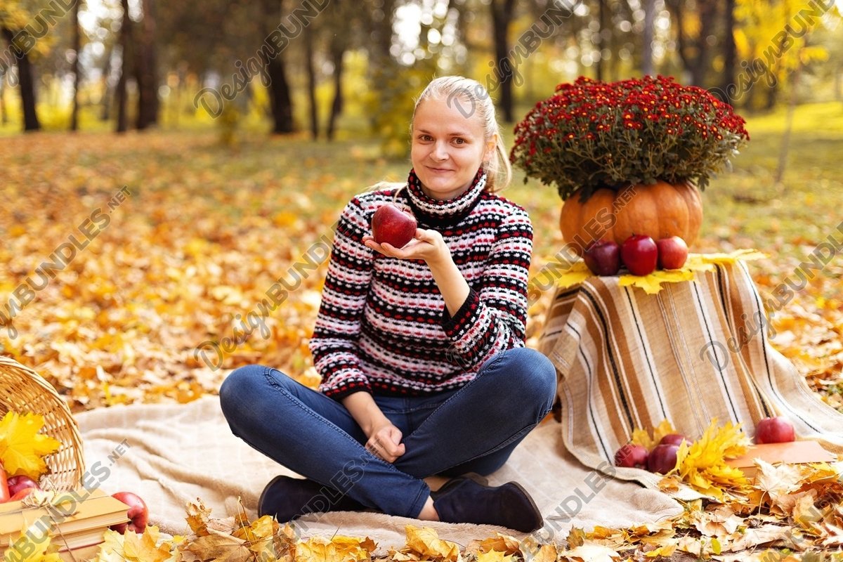 Photo of a Woman with apple on a picnic in the park example image 1