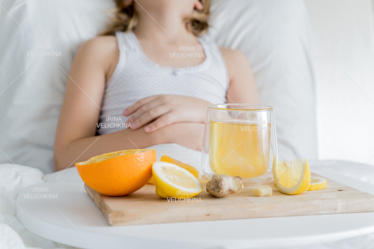 Sick girl in bed. Cup of flu drugs. Tea, orange,lemon,ginger example image 1