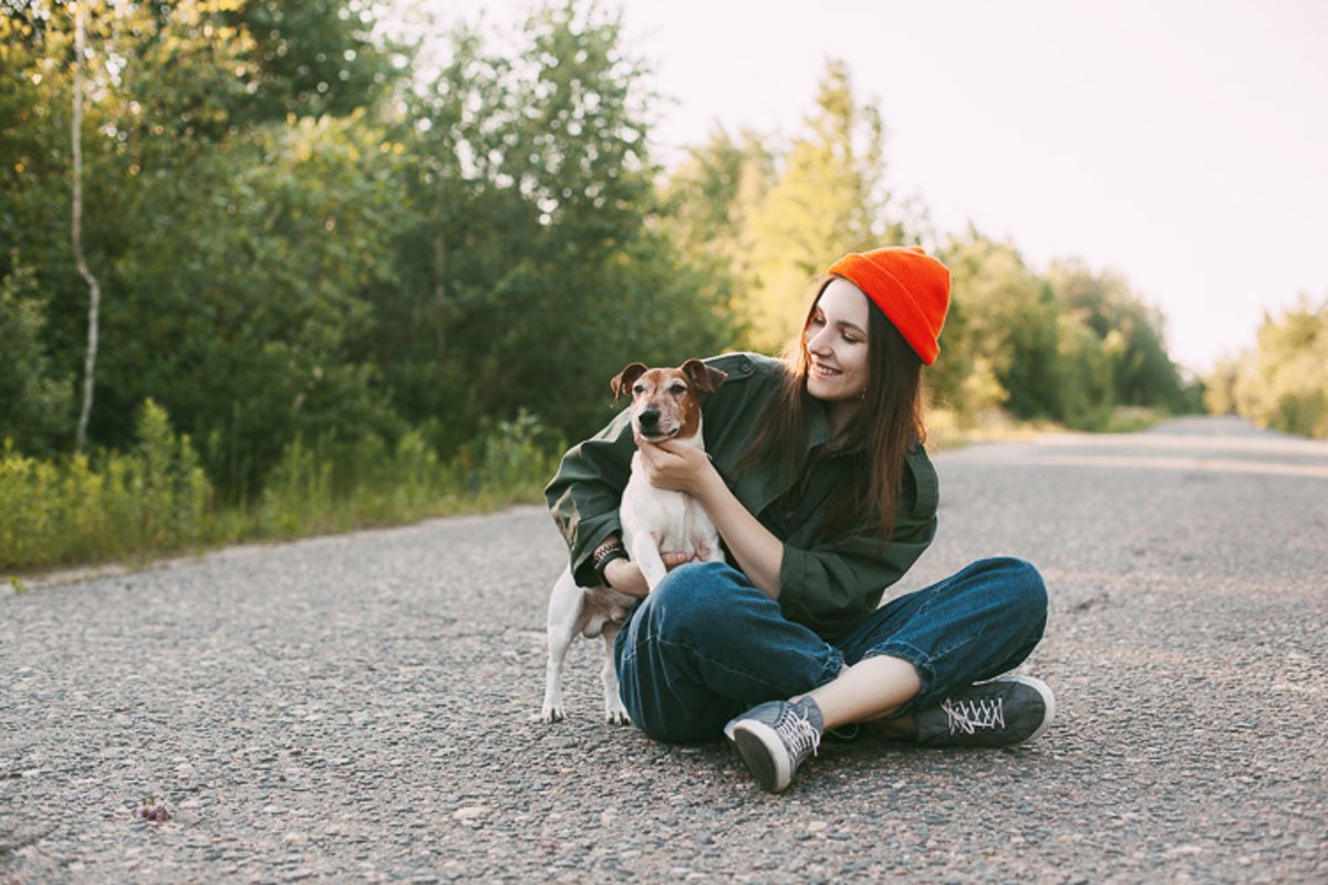 A charming teenage girl in an orange hat sits with her dog example image 1