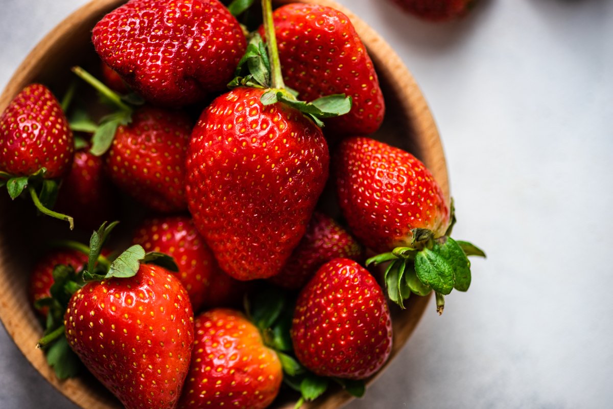 Organic summer berries in wooden bowl full of strawberries example image 1