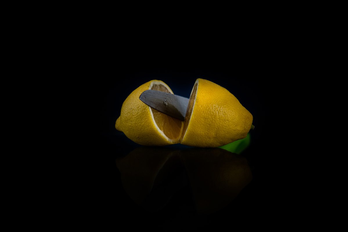 two halves of lemon cut with a knife on a black background example image 1