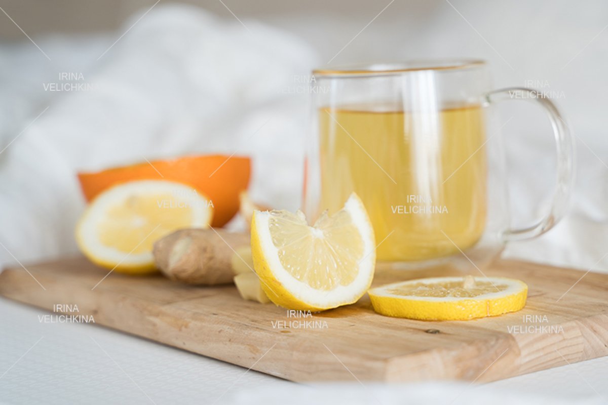 Cup of tea,orange,lemon,ginger in bed.Self treatment for flu example image 1