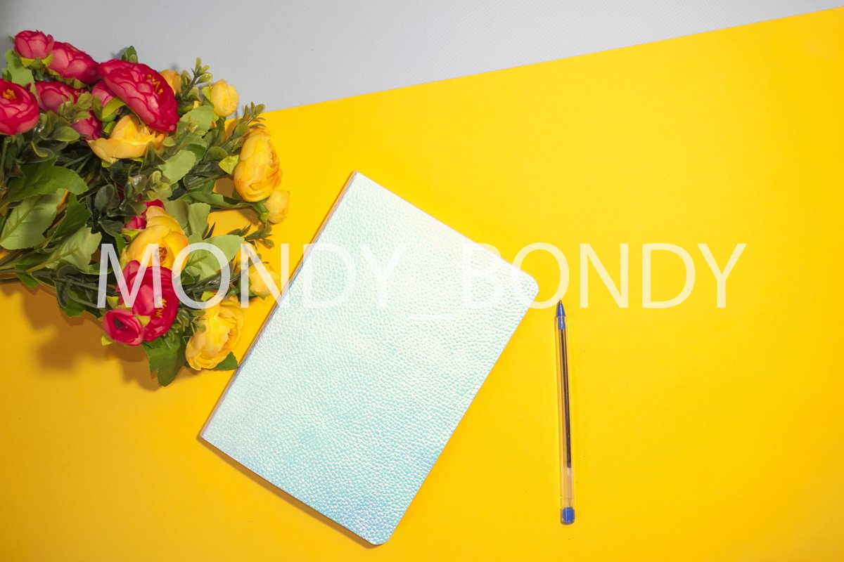 Flat lay. Holographic blue notebook and flowers on a colored example image 1