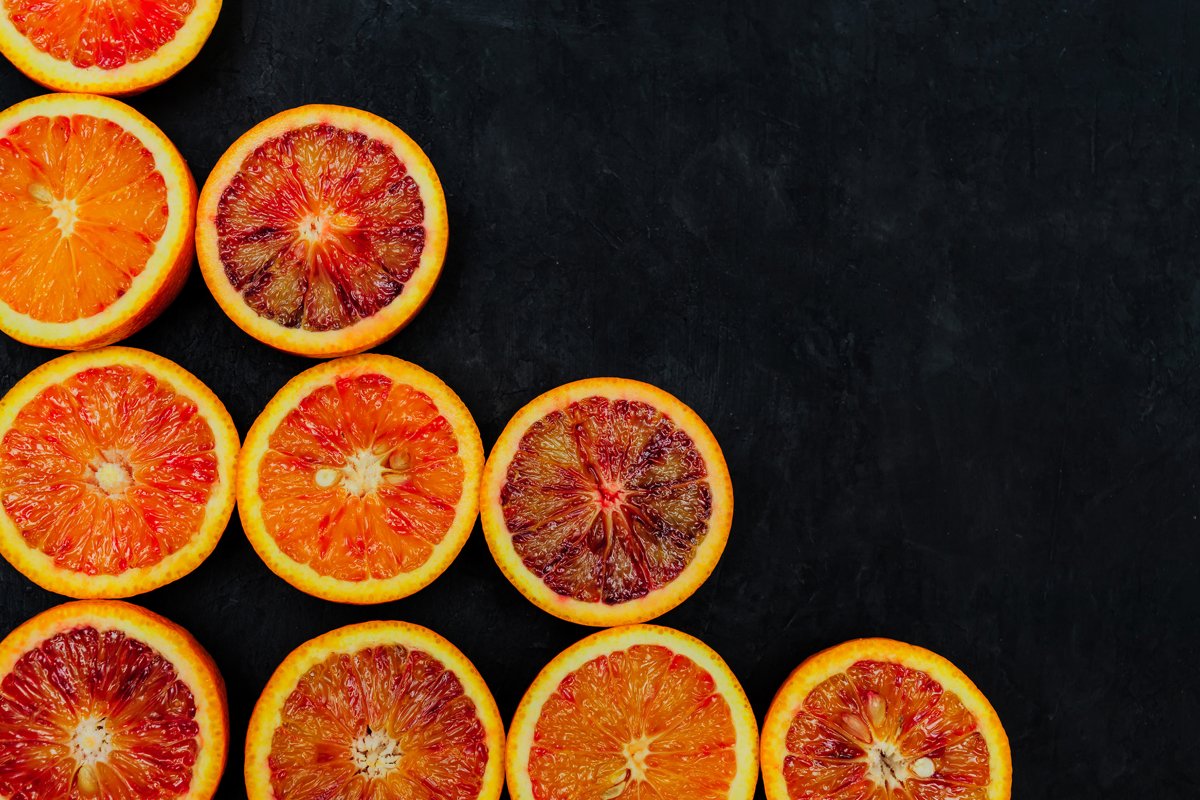 Organic Raw Red Blood Oranges in a rows on black background example image 1