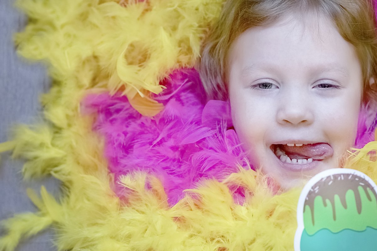A little girl lies in a blurred festive setting. Birthday example image 1