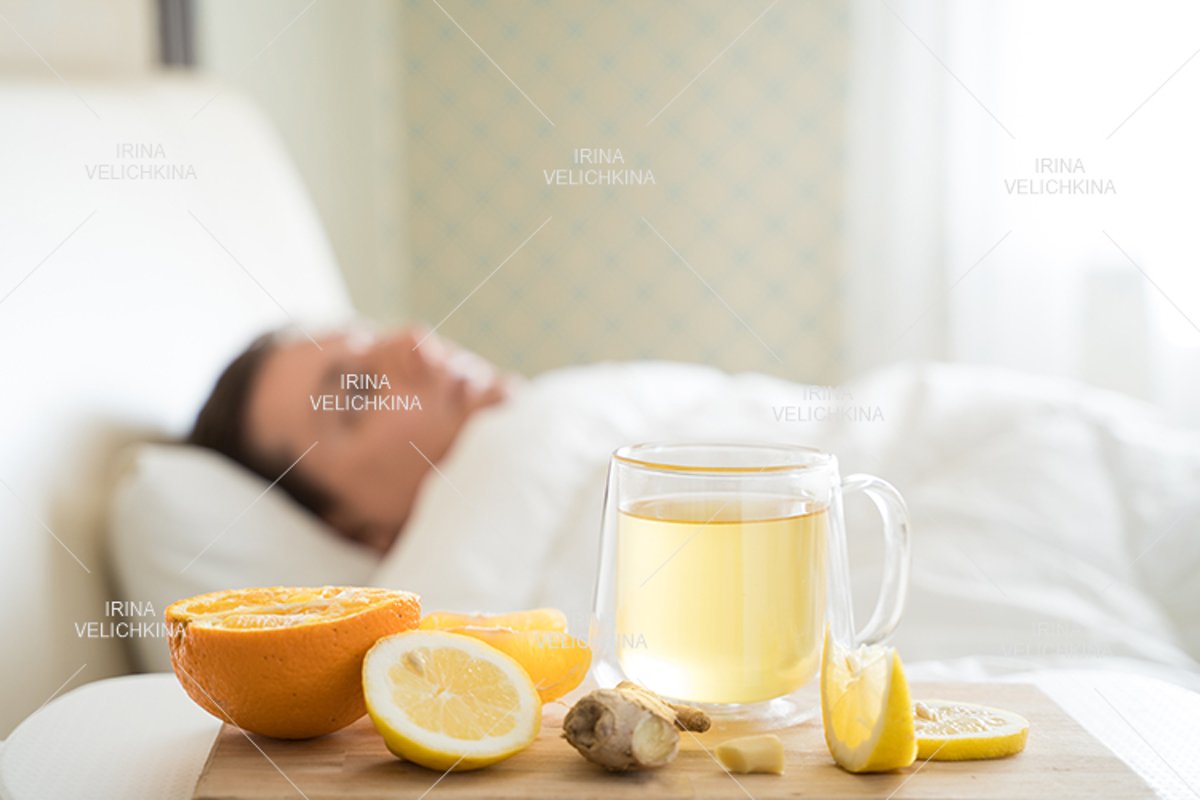 Sick man in bed. Cup of flu drugs. Tea, orange,lemon,ginger example image 1
