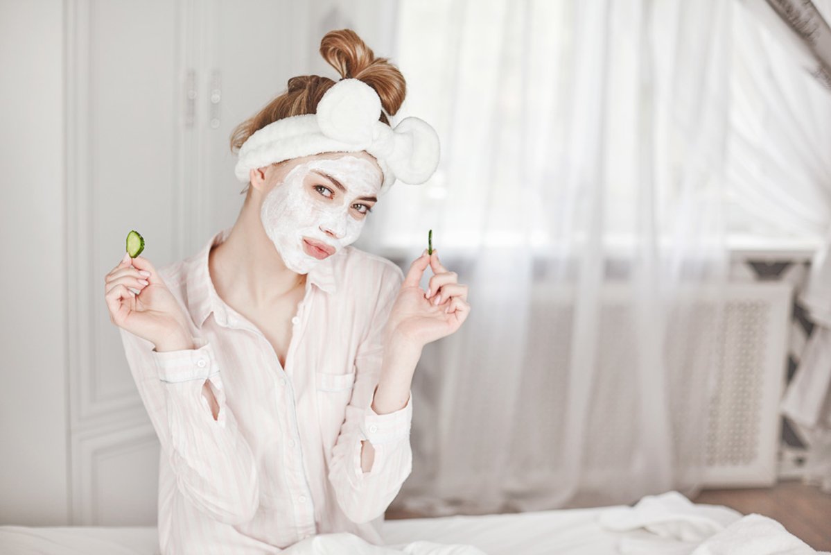 Girl with a face mask and slices of cucumber example image 1