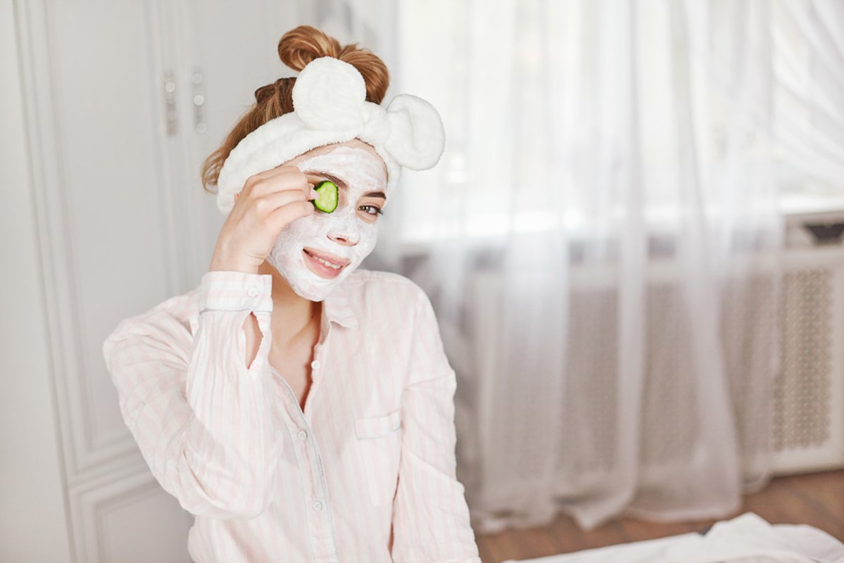 Girl with a face mask and slices of cucumber example image 1