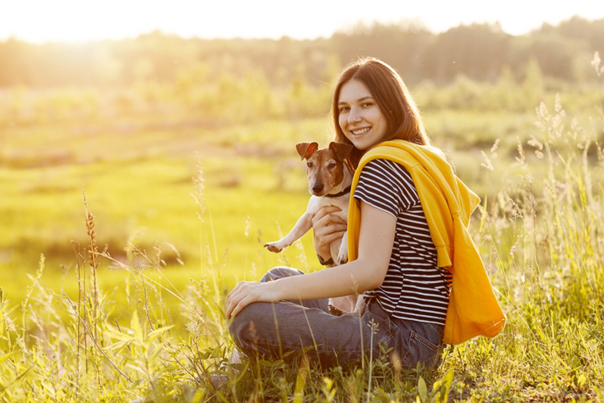 Young girl sitting on the grass and hugs a dog Jack Russell example image 1