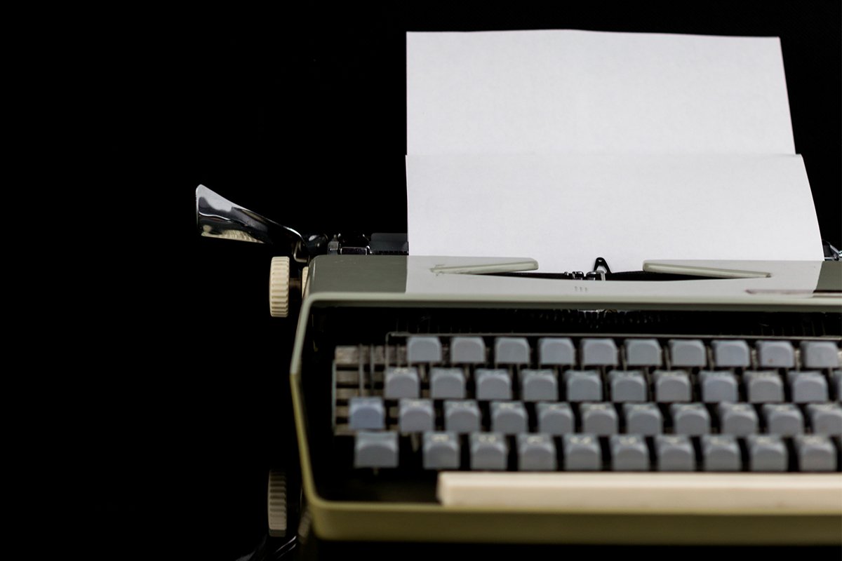Typewriter on the table on a black background example image 1