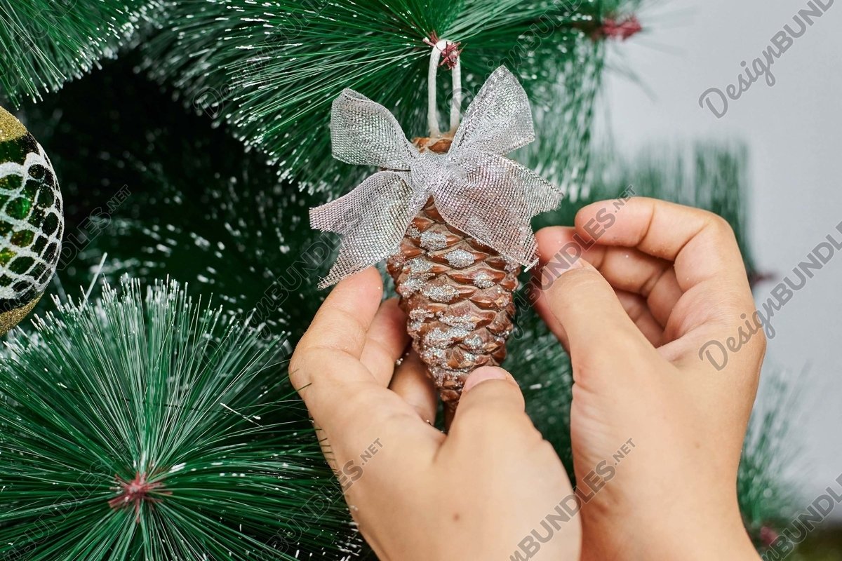 Stock Photo - Hands Of Woman Decorating Christmas Tree example image 1