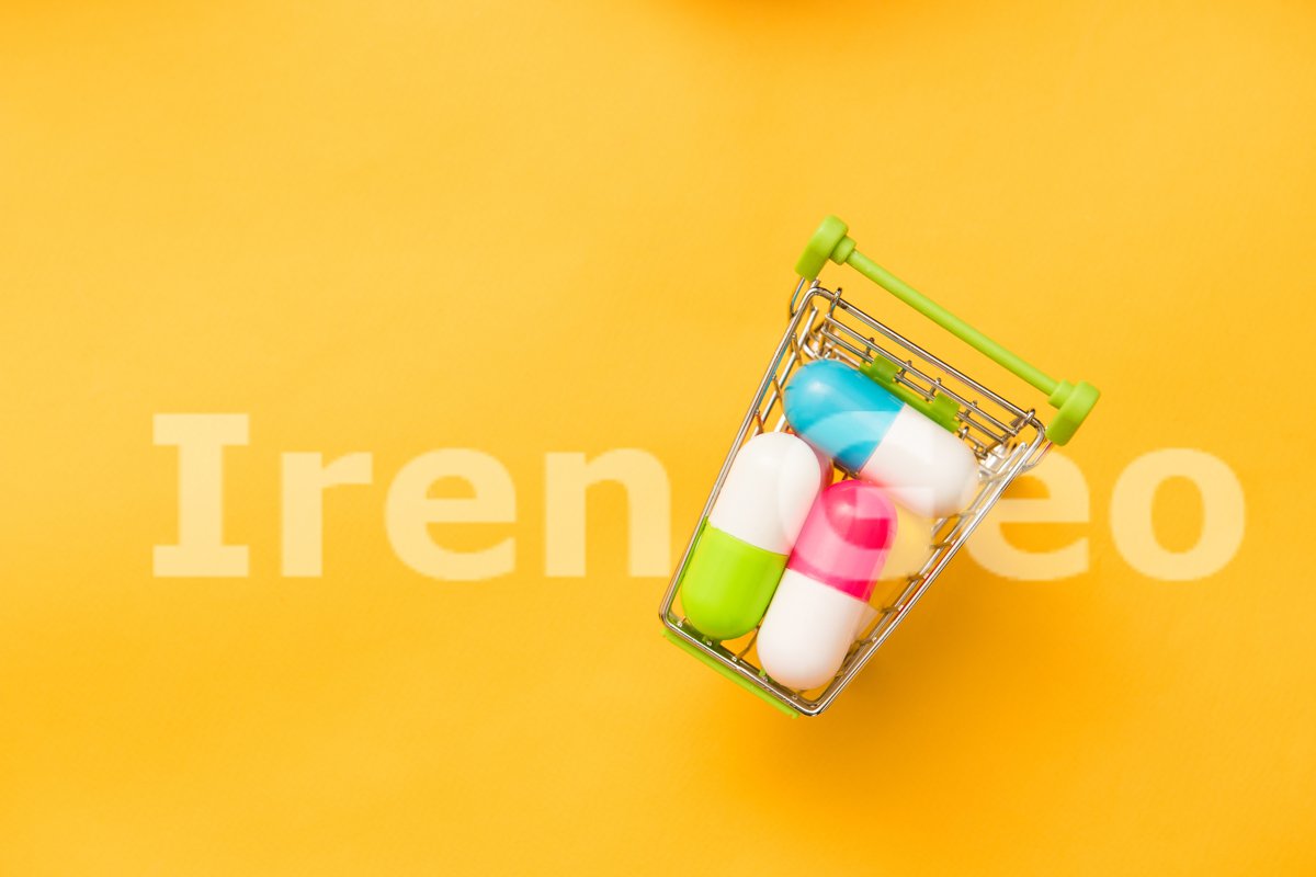 Small shopping cart full of pills on yellow background example image 1